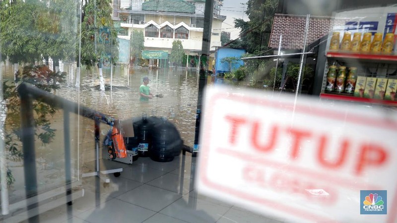 Warga melintas di komplek perumahan yang terendam banjir di Jatibening Permai, Bekasi, Jawa Barat, Jumat 19/2. Hujan yang mengguyur Kota Bekasi menyebabkan banjir di sejumlah titik. Bahkan ketinggian banjir di Perumahan Jatibening Permai mencapai perut orang dewasa. Hingga kini banjir belum juga surut. Peroses evakuasi masih berjalan. Perahu karet disiapkan untuk evakuasi warga yang masih di dalam perumahan. Diketahui terdapat 6 Kecamatan di Kota Bekasi yang tergenang akibat hujan. (վ/ Muhammad Sabki)