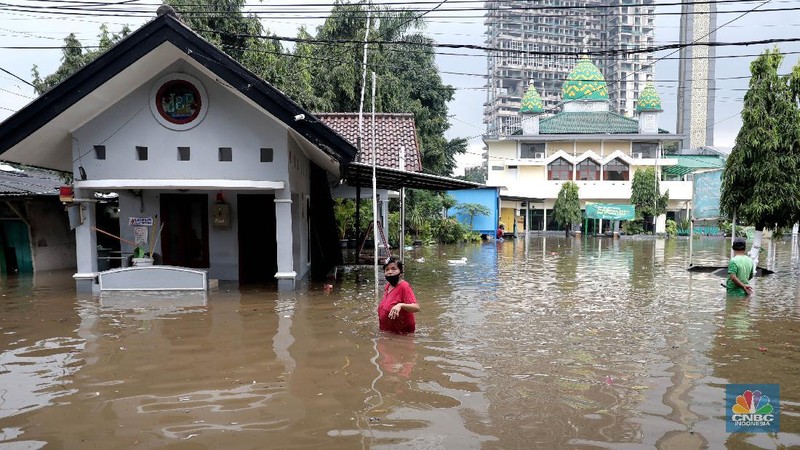 Warga melintas di komplek perumahan yang terendam banjir di Jatibening Permai, Bekasi, Jawa Barat, Jumat 19/2. Hujan yang mengguyur Kota Bekasi menyebabkan banjir di sejumlah titik. Bahkan ketinggian banjir di Perumahan Jatibening Permai mencapai perut orang dewasa. Hingga kini banjir belum juga surut. Peroses evakuasi masih berjalan. Perahu karet disiapkan untuk evakuasi warga yang masih di dalam perumahan. Diketahui terdapat 6 Kecamatan di Kota Bekasi yang tergenang akibat hujan. (վ/ Muhammad Sabki)