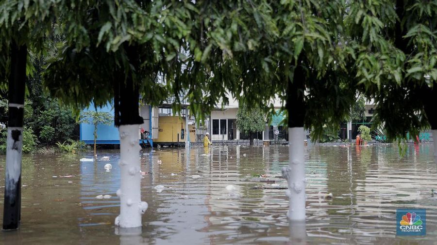Warga melintas di komplek perumahan yang terendam banjir di Jatibening Permai, Bekasi, Jawa Barat, Jumat 19/2. Hujan yang mengguyur Kota Bekasi menyebabkan banjir di sejumlah titik. Bahkan ketinggian banjir di Perumahan Jatibening Permai mencapai perut orang dewasa. Hingga kini banjir belum juga surut. Peroses evakuasi masih berjalan. Perahu karet disiapkan untuk evakuasi warga yang masih di dalam perumahan. Diketahui terdapat 6 Kecamatan di Kota Bekasi yang tergenang akibat hujan. (CNBC Indonesia/ Muhammad Sabki)