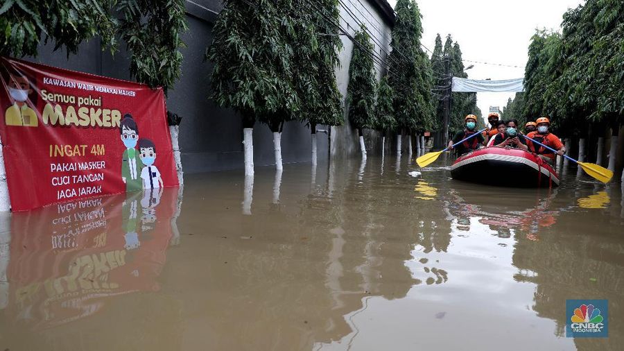 Warga melintas di komplek perumahan yang terendam banjir di Jatibening Permai, Bekasi, Jawa Barat, Jumat 19/2. Hujan yang mengguyur Kota Bekasi menyebabkan banjir di sejumlah titik. Bahkan ketinggian banjir di Perumahan Jatibening Permai mencapai perut orang dewasa. Hingga kini banjir belum juga surut. Peroses evakuasi masih berjalan. Perahu karet disiapkan untuk evakuasi warga yang masih di dalam perumahan. Diketahui terdapat 6 Kecamatan di Kota Bekasi yang tergenang akibat hujan. (վ/ Muhammad Sabki)