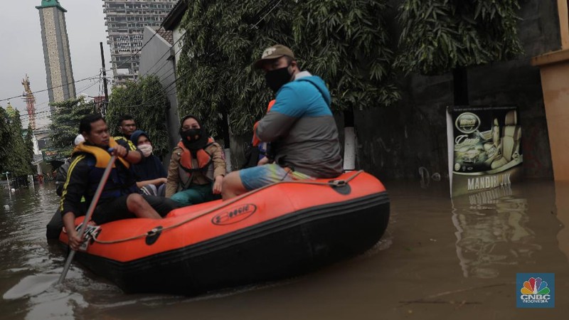 Warga melintas di komplek perumahan yang terendam banjir di Jatibening Permai, Bekasi, Jawa Barat, Jumat 19/2. Hujan yang mengguyur Kota Bekasi menyebabkan banjir di sejumlah titik. Bahkan ketinggian banjir di Perumahan Jatibening Permai mencapai perut orang dewasa. Hingga kini banjir belum juga surut. Peroses evakuasi masih berjalan. Perahu karet disiapkan untuk evakuasi warga yang masih di dalam perumahan. Diketahui terdapat 6 Kecamatan di Kota Bekasi yang tergenang akibat hujan. (վ/ Muhammad Sabki)