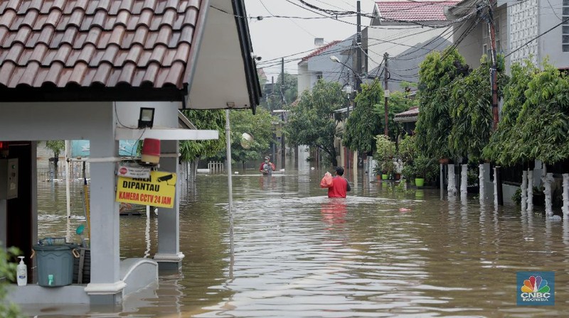 Warga melintas di komplek perumahan yang terendam banjir di Jatibening Permai, Bekasi, Jawa Barat, Jumat 19/2. Hujan yang mengguyur Kota Bekasi menyebabkan banjir di sejumlah titik. Bahkan ketinggian banjir di Perumahan Jatibening Permai mencapai perut orang dewasa. Hingga kini banjir belum juga surut. Peroses evakuasi masih berjalan. Perahu karet disiapkan untuk evakuasi warga yang masih di dalam perumahan. Diketahui terdapat 6 Kecamatan di Kota Bekasi yang tergenang akibat hujan. (վ/ Muhammad Sabki)