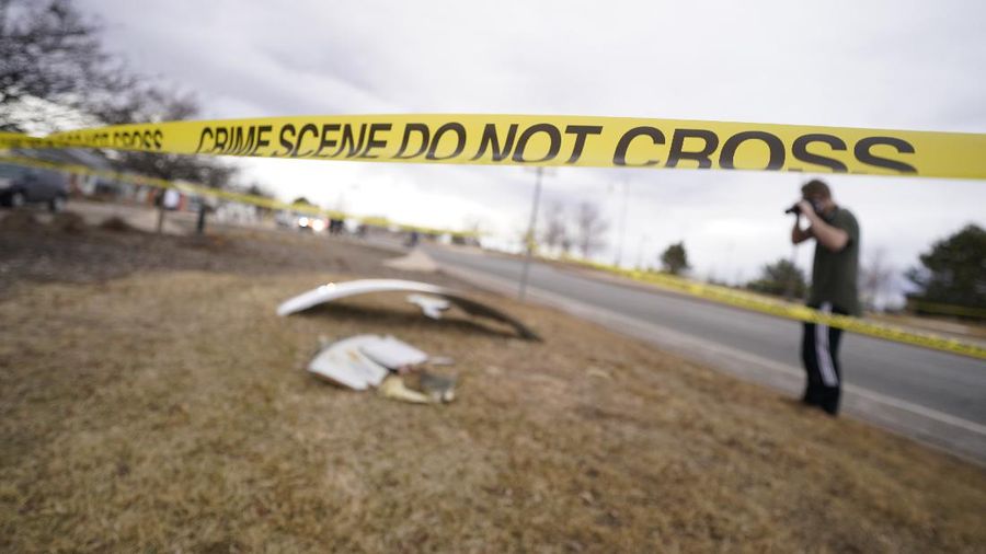 A North Metro firefighter walks past a large piece of an airplane engine in the front yard of a home on Elmwood Street near E. 13th Avenue, Saturday, Feb. 20, 2021, in Broomfield, Colo. Debris from a United Airlines plane fell onto Denver suburbs during an emergency landing Saturday after one of its engines suffered a catastrophic failure and rained pieces of the engine casing on a neighborhood where it narrowly missed a home. (Andy Cross/The Denver Post via AP)