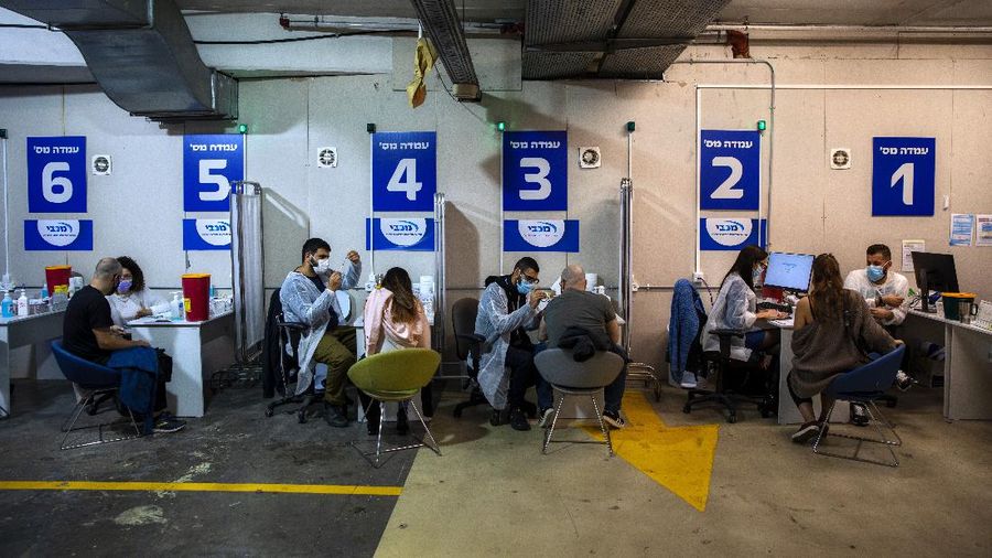 In this Feb. 4, 2021 file photo, Israelis receive a Pfizer-BioNTech COVID-19 vaccine from medical professionals at a coronavirus vaccination center set up on a shopping mall parking lot in Givataim, Israel. Candidates hoping to topple Benjamin Netanyahu in next month’s election are looking to the U.S. experience of 2020 for lessons about campaigning during a pandemic. (AP Photo/Oded Balilty, File)