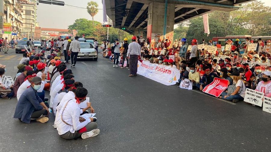 Anti-coup protesters hold signs that read 