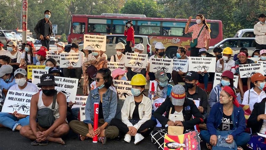 Anti-coup protesters hold signs that read 