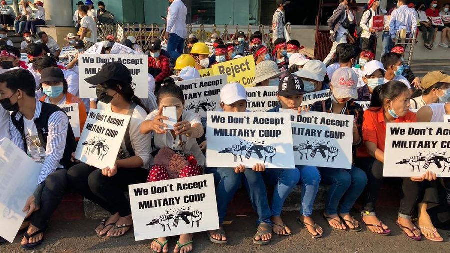 Anti-coup protesters hold signs that read 