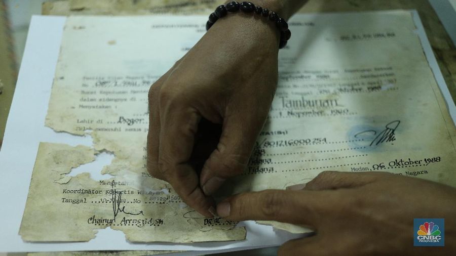 Petugas restorasi ARSIP Nasional Republik Indonesia (ANRI) melakukan perbaikan dokumen milik warga yang terdampak banjir, Jakarta, Senin ( 22/2/2021). Dokumen yang rusak seperti Ijazah hingga akte kelahiran akan diperbaiki 1 sampai 4 Minggu. Contoh arsip keluarga yang bisa diperbaiki dari kerusakan banjir adalah akte, surat perkawinan, akte kelahiran, surat kematian, STTB dll. Maksimal berkas yang diterima 10 lembar.  (CNBC Indonesia/ Tri Susilo)