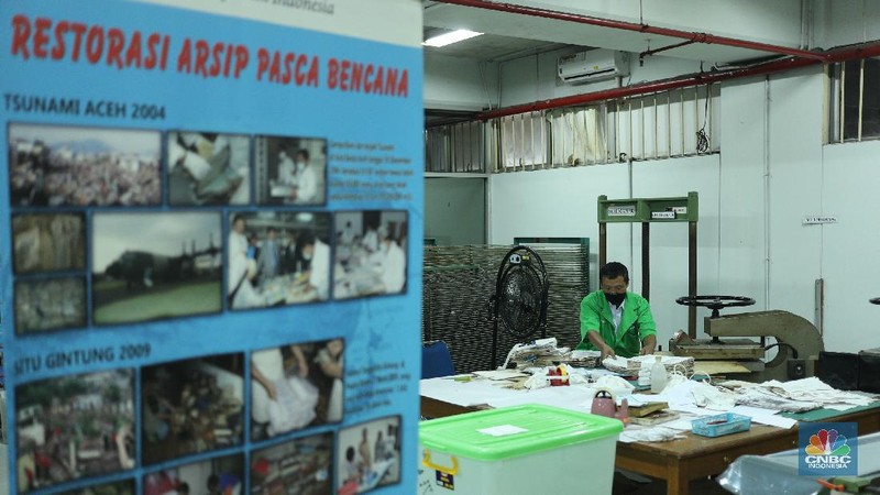 Petugas restorasi ARSIP Nasional Republik Indonesia (ANRI) melakukan perbaikan dokumen milik warga yang terdampak banjir, Jakarta, Senin ( 22/2/2021). Dokumen yang rusak seperti Ijazah hingga akte kelahiran akan diperbaiki 1 sampai 4 Minggu. Contoh arsip keluarga yang bisa diperbaiki dari kerusakan banjir adalah akte, surat perkawinan, akte kelahiran, surat kematian, STTB dll. Maksimal berkas yang diterima 10 lembar.  (CNBC Indonesia/ Tri Susilo)