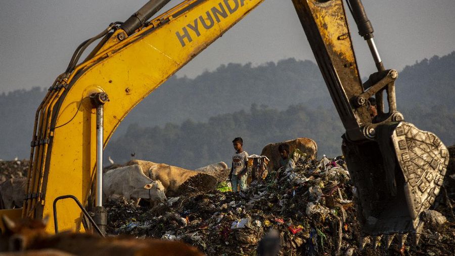 Imradul Ali, 10, left, and his mother Anuwara Beghum, 30, take a break as they look for recyclable material at a landfill on the outskirts of Gauhati, India, Thursday, Feb. 4, 2021. Once school is done for the day, Ali, rushes home to change out of his uniform so that he can start his job as a scavenger in India’s remote northeast. Coming from a family of scavengers or “rag pickers,