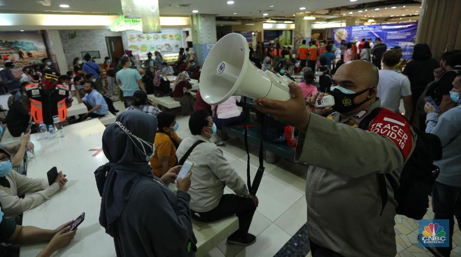 Petugas gabungan membubarkan kerumunan antrian vaksinasi pedagang di Pasar Tanah Abang, Jakarta, Selasa (23/2/2021). Sejumlah pedagang masih bertahan dilokasi ujtuk menunggu informasi lebih lanjut. Wina (43) pedagang pakaian Blok A menjelaskan, antrian mulai mengular mulai pukul 10.00 wib di lantai 8 hingga 9, kerumunan juga terjadi karena antrian tidak menggunakan nomor antrian jelasnya. Pantauan CNBC Indonesia dilapangan pedagang masih ada yang menunggu di lantai 8 untuk meminta info lebih lanjut untuk penyuntikan vaksin. (CNBC Indonesia/ Tri Susilo)