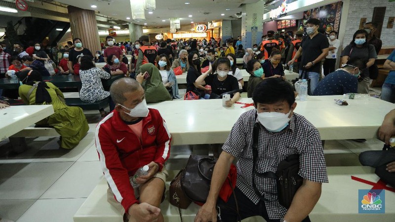 Petugas gabungan membubarkan kerumunan antrian vaksinasi pedagang di Pasar Tanah Abang, Jakarta, Selasa (23/2/2021). Sejumlah pedagang masih bertahan dilokasi ujtuk menunggu informasi lebih lanjut. Wina (43) pedagang pakaian Blok A menjelaskan, antrian mulai mengular mulai pukul 10.00 wib di lantai 8 hingga 9, kerumunan juga terjadi karena antrian tidak menggunakan nomor antrian jelasnya. Pantauan CNBC Indonesia dilapangan pedagang masih ada yang menunggu di lantai 8 untuk meminta info lebih lanjut untuk penyuntikan vaksin. (CNBC Indonesia/ Tri Susilo)