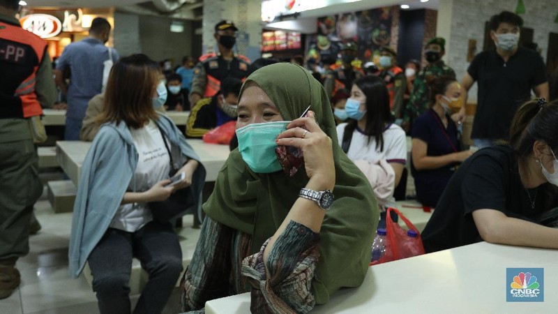 Petugas gabungan membubarkan kerumunan antrian vaksinasi pedagang di Pasar Tanah Abang, Jakarta, Selasa (23/2/2021). Sejumlah pedagang masih bertahan dilokasi ujtuk menunggu informasi lebih lanjut. Wina (43) pedagang pakaian Blok A menjelaskan, antrian mulai mengular mulai pukul 10.00 wib di lantai 8 hingga 9, kerumunan juga terjadi karena antrian tidak menggunakan nomor antrian jelasnya. Pantauan CNBC Indonesia dilapangan pedagang masih ada yang menunggu di lantai 8 untuk meminta info lebih lanjut untuk penyuntikan vaksin. (CNBC Indonesia/ Tri Susilo)