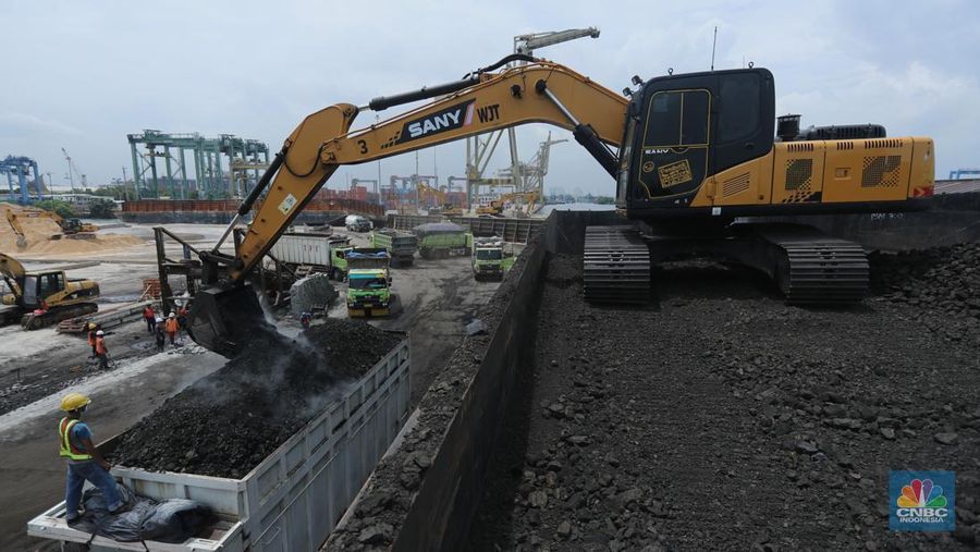 Pekerja melakukan bongkar muat batu bara di Terminal Tanjung Priok, Jakarta, Selasa (23/2/2021). Pemerintah telah mengeluarkan peraturan turunan dari Undang-Undang No. 11 tahun 2020 tentang Cipta Kerja. Adapun salah satunya Peraturan Pemerintah yang diterbitkan yaitu Peraturan Pemerintah No.25 tahun 2021 tentang Penyelenggaraan Bidang Energi dan Sumber Daya Mineral.  (CNBC Indonesia/ Tri Susilo)