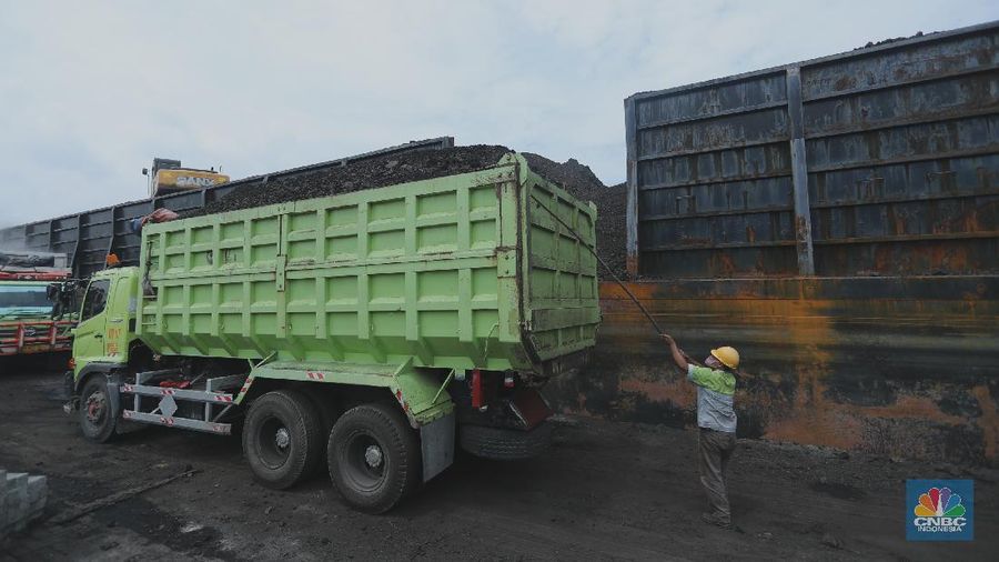 Pekerja melakukan bongkar muat batu bara di Terminal Tanjung Priok, Jakarta, Selasa (23/2/2021). Pemerintah telah mengeluarkan peraturan turunan dari Undang-Undang No. 11 tahun 2020 tentang Cipta Kerja. Adapun salah satunya Peraturan Pemerintah yang diterbitkan yaitu Peraturan Pemerintah No.25 tahun 2021 tentang Penyelenggaraan Bidang Energi dan Sumber Daya Mineral.  (CNBC Indonesia/ Tri Susilo)