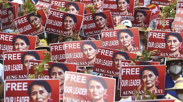 Demo dan Mogok Kerja Akibat Kudeta Militer di Myanmar Protesters hold up placard with images of ousted leader Aung San Suu Kyi during an anti-coup protest in Mandalay, Myanmar, Sunday, Feb. 21, 2021. Police in Myanmar shot dead a few anti-coup protesters and injured several others on Saturday, as security forces increased pressure on popular revolt against the military takeover. (AP Photo)