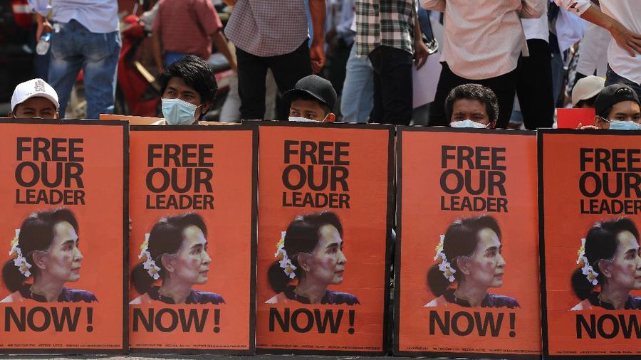 Anti-coup protesters sit behind posters with an image of deposed Myanmar leader Aung San Suu Kyi during a rally in Yangon, Myanmar, Monday, Feb. 22, 2021. Protesters gathered in Myanmar's biggest city Monday despite the ruling junta's thinly veiled threat to use lethal force if people answered a call for a general strike opposing the military takeover three weeks ago. (AP Photos)