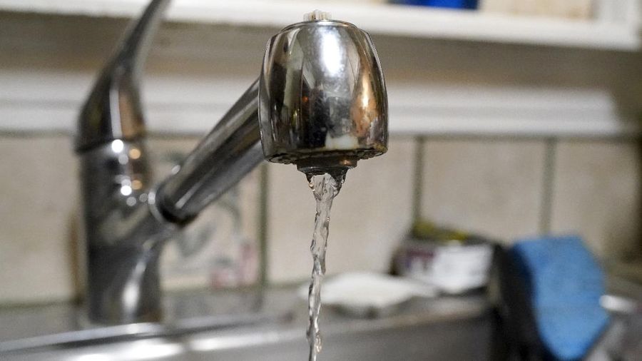Water pours slowly out of the faucet on Saturday, Feb. 20, 2021, in Dallas, in the home of Nora Espinoza, after a handyman made a repair to a broken pipe beneath the sink. After the repair was made, another leak was discovered in a broken pipe outside of the home. (AP Photo/Tony Gutierrez)