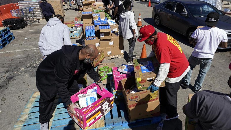 Volunteers load vehicles with food and water at a distribution site Monday, Feb. 22, 2021, in Houston. The city's boil water notice has been rescinded however many residents lack water at home due to broken pipes. (AP Photo/David J. Phillip)