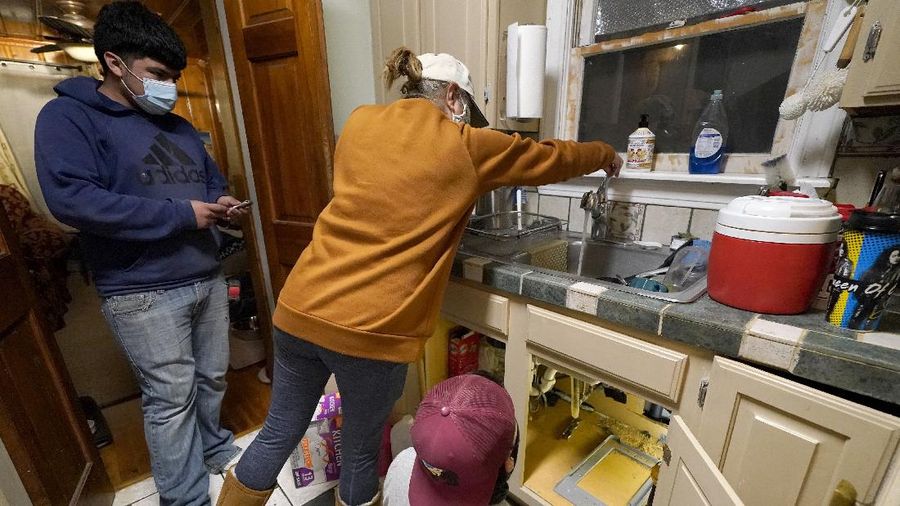 Volunteers load vehicles with food and water at a distribution site Monday, Feb. 22, 2021, in Houston. The city's boil water notice has been rescinded however many residents lack water at home due to broken pipes. (AP Photo/David J. Phillip)