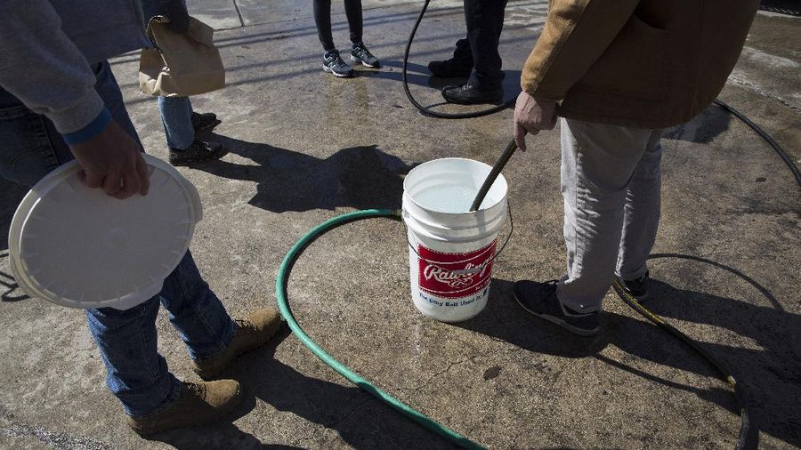 Volunteers load vehicles with food and water at a distribution site Monday, Feb. 22, 2021, in Houston. The city's boil water notice has been rescinded however many residents lack water at home due to broken pipes. (AP Photo/David J. Phillip)