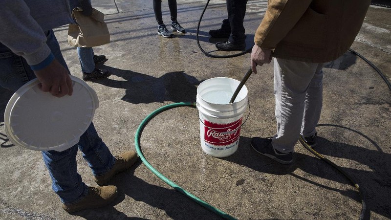 Volunteers load vehicles with food and water at a distribution site Monday, Feb. 22, 2021, in Houston. The city's boil water notice has been rescinded however many residents lack water at home due to broken pipes. (AP Photo/David J. Phillip)