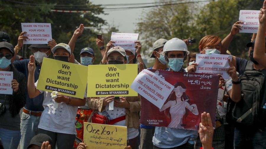 A policeman stands guard as demonstrators display placards during a protest close to Indonesian embassy in Yangon, Myanmar Tuesday, Feb. 23, 2021. Anti-coup protesters gathered outside the Indonesian Embassy following reports that Indonesia was seeking to have fellow members of the Association of Southeast Asian Nations to agree on an action plan over the Myanmar’s coup that would hold the junta  to its promise to hold free and fair elections in a year's time. The Indonesia Foreign Ministry has denied the report. (AP Photo)