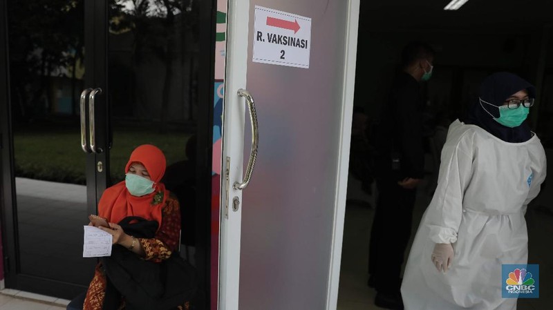 Tenaga pendidikan jalani vaksinasi Covid-19 di SMA Negeri 70, Bulungan, Kebayoran Baru, Jakarta Selatan, Rabu (24/2/2021). Ratusan guru dan tenaga pendidik dari PGRI divaksinasi COVID-19. Perwakilan kali ini datang dari wilayah Jabodetabek. Pihak yang divaksinasi hari ini terdiri dari Organisasi Guru Undangan Ditjen GTK, Guru Disdik Provinsi DKI Jakarta, hingga organisasi PGRI. Vaksinasi pendidik ditargetkan selesai pada Juni 2021, sehingga proses pembelajaran tatap muka di sekolah bisa dimulai pada tahun ajaran baru 2021/2022, atau pada Juli mendatang. Kementerian Kesehatan menargetkan total sasaran penerima vaksin dari pendidik (guru, dosen, tenaga pendidik) di seluruh Indonesia berjumlah 5.058.582 orang pada vaksinasi tahap kedua ini. (CNBC Indonesia/ Muhammad Sabki)