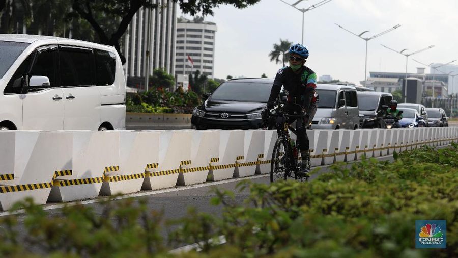 Pesepeda melintas di jalur sepeda di Kawasan Sudirman-Thamrin, Jakarta, Jumat (26/2). Pemprov DKI Jakarta mulai mempermanenkan jalur sepeda di Jalan Sudirman-Thamrin, Jakarta Pusat. Begini potret pembatas jalur sepeda yang mulai terpasang. Meski sudah dibatasi pantauan CNBC Indonesia beberapa pemotor masih masuk ke jalur sepeda permanen saat arus lalu lintas sedang ramai lancar. Para pemotor terlihat menaikkan kecepatannya saat melintas di jalur sepeda permanen.Tak jarang pula para pemotor tersebut berhenti sejenak di sekitar jalur sepeda permanen. (CNBC Indonesia/ Muhammad Sabki)