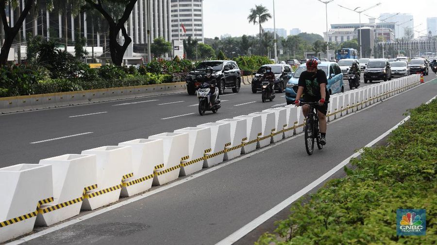 Pesepeda melintas di jalur sepeda di Kawasan Sudirman-Thamrin, Jakarta, Jumat (26/2). Pemprov DKI Jakarta mulai mempermanenkan jalur sepeda di Jalan Sudirman-Thamrin, Jakarta Pusat. Begini potret pembatas jalur sepeda yang mulai terpasang. Meski sudah dibatasi pantauan CNBC Indonesia beberapa pemotor masih masuk ke jalur sepeda permanen saat arus lalu lintas sedang ramai lancar. Para pemotor terlihat menaikkan kecepatannya saat melintas di jalur sepeda permanen.Tak jarang pula para pemotor tersebut berhenti sejenak di sekitar jalur sepeda permanen. (CNBC Indonesia/ Muhammad Sabki)