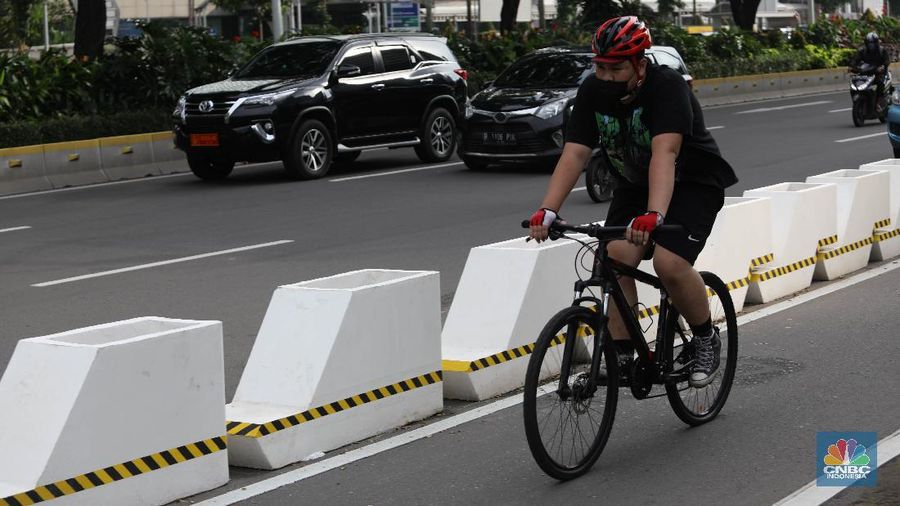 Pesepeda melintas di jalur sepeda di Kawasan Sudirman-Thamrin, Jakarta, Jumat (26/2). Pemprov DKI Jakarta mulai mempermanenkan jalur sepeda di Jalan Sudirman-Thamrin, Jakarta Pusat. Begini potret pembatas jalur sepeda yang mulai terpasang. Meski sudah dibatasi pantauan CNBC Indonesia beberapa pemotor masih masuk ke jalur sepeda permanen saat arus lalu lintas sedang ramai lancar. Para pemotor terlihat menaikkan kecepatannya saat melintas di jalur sepeda permanen.Tak jarang pula para pemotor tersebut berhenti sejenak di sekitar jalur sepeda permanen. (CNBC Indonesia/ Muhammad Sabki)