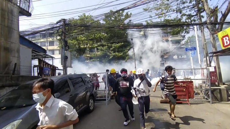 Polisi menembakan gas air mata saat demo di Myanmar. AP/