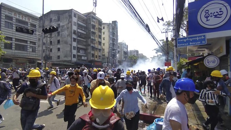 Polisi menembakan gas air mata saat demo di Myanmar. AP/