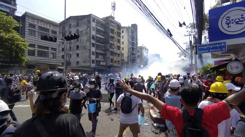 Polisi menembakan gas air mata saat demo di Myanmar. AP/