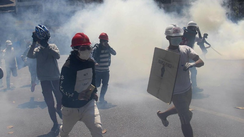 Polisi menembakan gas air mata saat demo di Myanmar. AP/