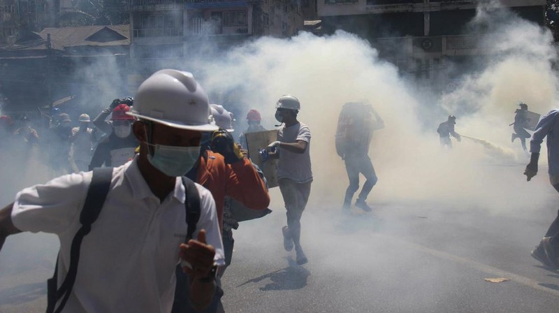 Polisi menembakan gas air mata saat demo di Myanmar. AP/