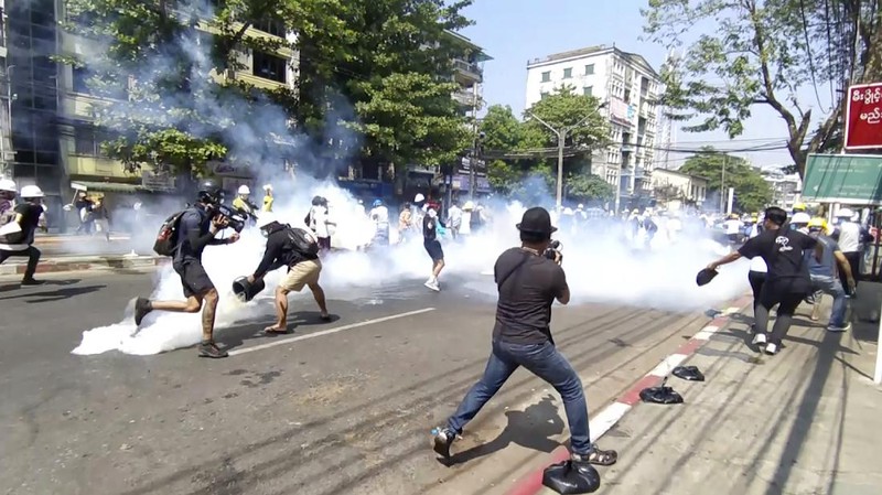 Polisi menembakan gas air mata saat demo di Myanmar. AP/