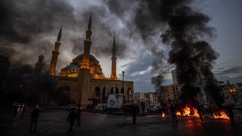 Warga Lebanon marah memblokir seluruh jalan dengan membakar ban dan tempat sampah setelah mata uang Lebanon jatuh ke titik terendah baru dalam krisis ekonomi. (AP/Hussein Malla)