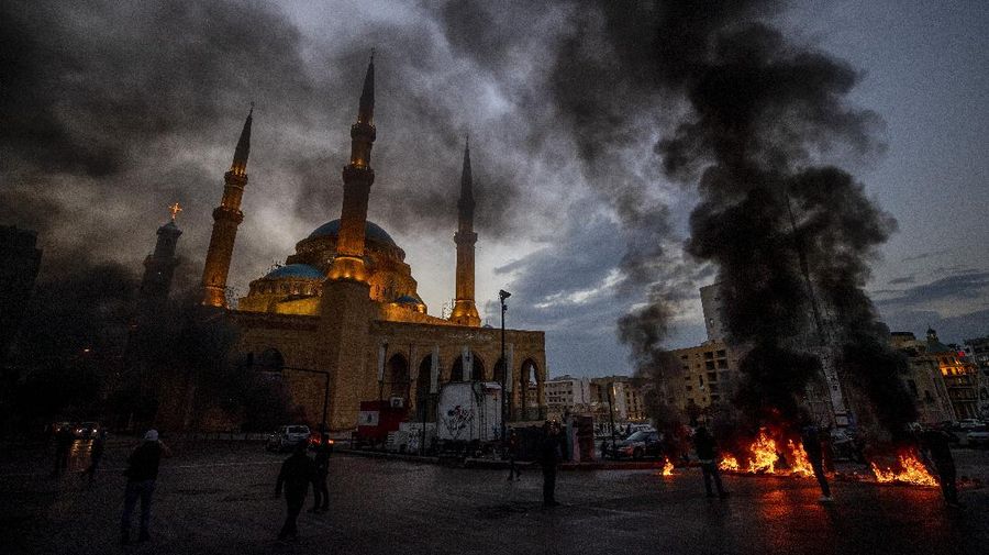 Warga Lebanon marah memblokir seluruh jalan dengan membakar ban dan tempat sampah setelah mata uang Lebanon jatuh ke titik terendah baru dalam krisis ekonomi. (AP/Hassan Ammar)
