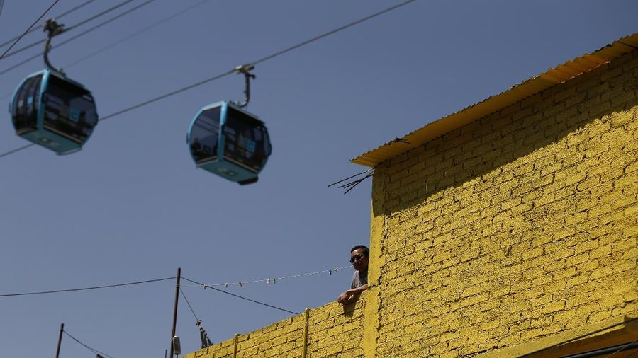 Officials and journalists ride in cable cars between the Campos Revolucion and Tlalpexco stations, during the inauguration of a new aerial public transit system dubbed the Cablebus, in the Cuautepec neighborhood of northern Mexico City, Thursday, March 4, 2021. For the residents of Cuautepec, this new system, the first of four planned lines, will turn a commute to the nearest subway station, that can last up to two hours, into a 30-minute ride. (AP Photo/Rebecca Blackwell)
