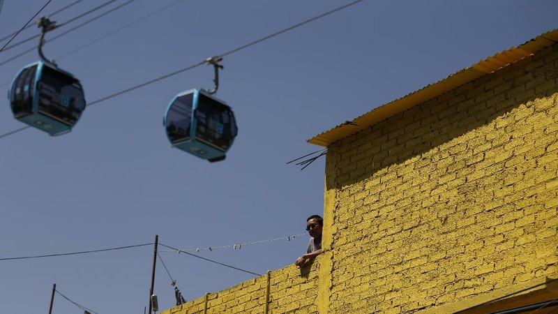 Officials and journalists ride in cable cars between the Campos Revolucion and Tlalpexco stations, during the inauguration of a new aerial public transit system dubbed the Cablebus, in the Cuautepec neighborhood of northern Mexico City, Thursday, March 4, 2021. For the residents of Cuautepec, this new system, the first of four planned lines, will turn a commute to the nearest subway station, that can last up to two hours, into a 30-minute ride. (AP Photo/Rebecca Blackwell)