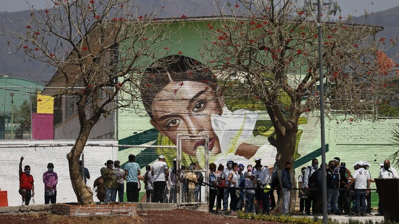 Officials and journalists ride in cable cars between the Campos Revolucion and Tlalpexco stations, during the inauguration of a new aerial public transit system dubbed the Cablebus, in the Cuautepec neighborhood of northern Mexico City, Thursday, March 4, 2021. For the residents of Cuautepec, this new system, the first of four planned lines, will turn a commute to the nearest subway station, that can last up to two hours, into a 30-minute ride. (AP Photo/Rebecca Blackwell)