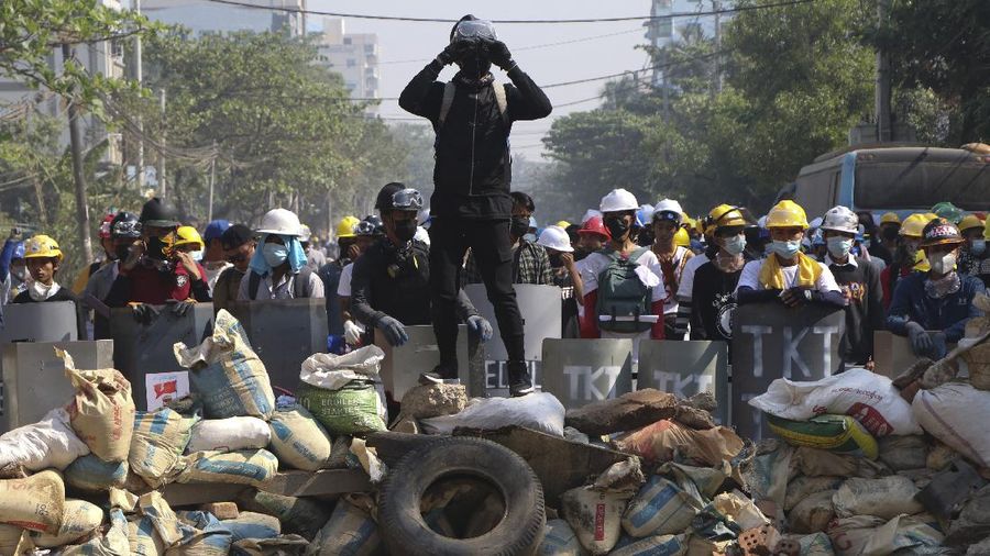 Riot police officers move in to disperse protesters during a demonstration in Yangon, Sunday, March 7, 2021. The escalation of violence in Myanmar as authorities crack down on protests against the Feb. 1 coup is raising pressure for more sanctions against the junta, even as countries struggle over how to best sway military leaders inured to global condemnation. (AP Photo)