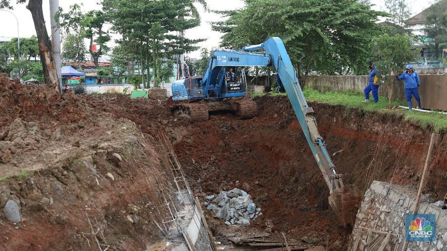 Sejumlah petugas Suku Dinas Sumber Daya Air (SDA) Jakarta Pusat mengerjakan pembuatan embung di Jalan Letjend Suprapto, Sumur Batu, Kemayoran, Jakarta Pusat, Senin (8/3/2021). (CNBC Indonesia/Andrean Kristianto)