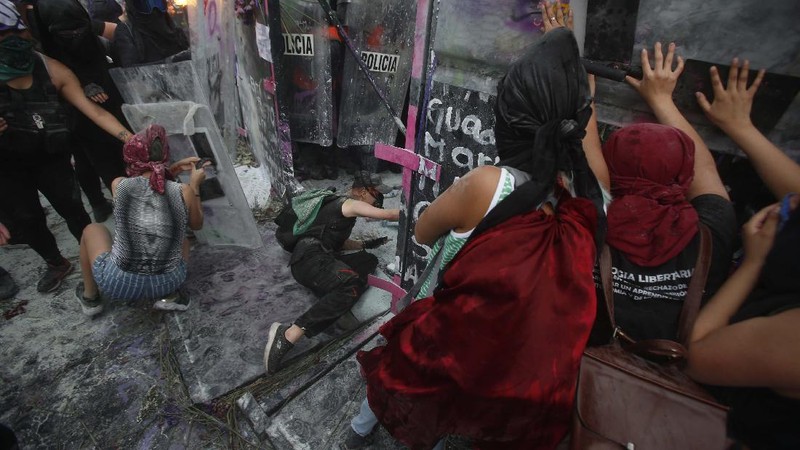 Pasukan polisi dan para aktivis terlibat bentrok di ibu Kota Meksiko di tengah aksi unjuk rasa memperingati Hari Perempuan Internasional, Senin (8/3/2021). (AP/Rebecca Blackwell)