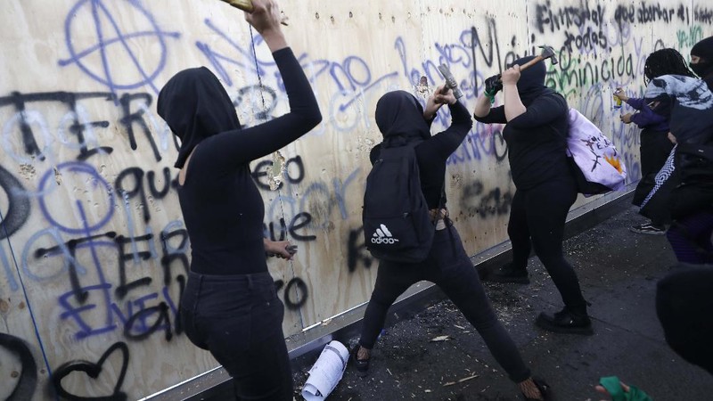 Pasukan polisi dan para aktivis terlibat bentrok di ibu Kota Meksiko di tengah aksi unjuk rasa memperingati Hari Perempuan Internasional, Senin (8/3/2021). (AP/Rebecca Blackwell)