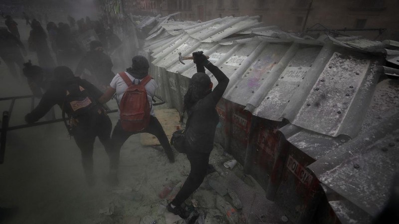 Pasukan polisi dan para aktivis terlibat bentrok di ibu Kota Meksiko di tengah aksi unjuk rasa memperingati Hari Perempuan Internasional, Senin (8/3/2021). (AP/Rebecca Blackwell)