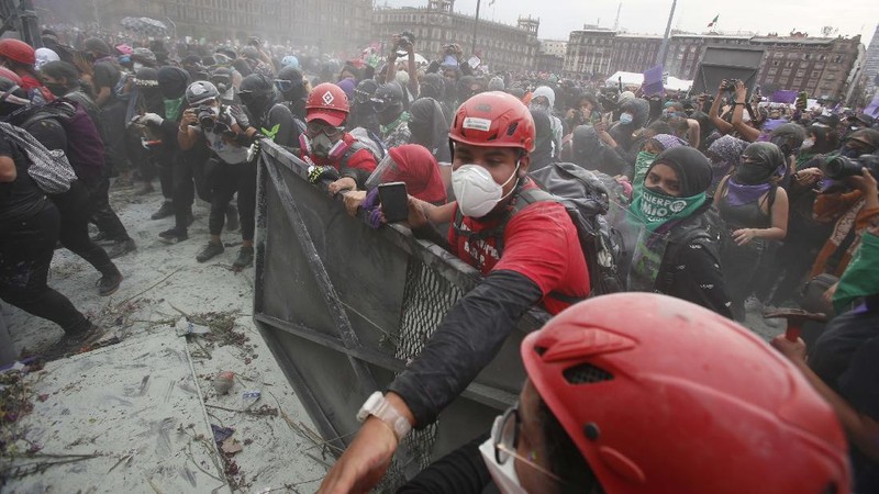 Pasukan polisi dan para aktivis terlibat bentrok di ibu Kota Meksiko di tengah aksi unjuk rasa memperingati Hari Perempuan Internasional, Senin (8/3/2021). (AP/Rebecca Blackwell)