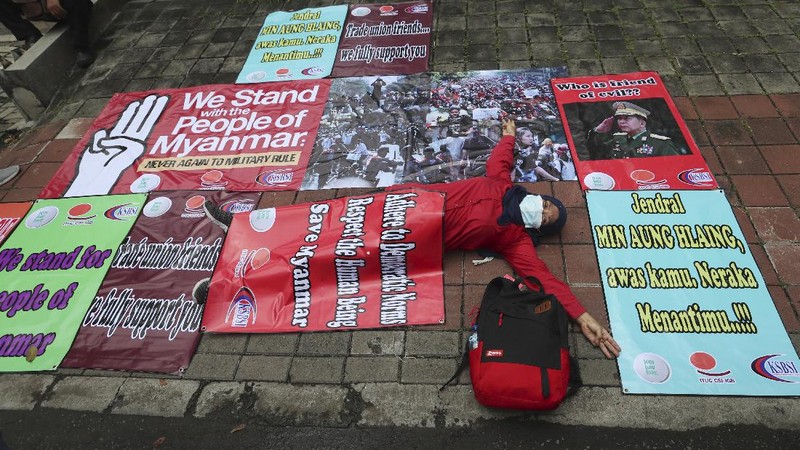 Labor activists destroy a poster of a defaced image of Commander in Chief, Sen. Gen. Min Aung Hlaing during a protest outside the Embassy of Myanmar in Jakarta, Indonesia , Wednesday, March 10, 2021. Dozens of Indonesian labor activists angered over the military coup in Myanmar protested Wednesday outside the Myanmar Embassy in the Indonesian capital. (AP Photo/Achmad Ibrahim)