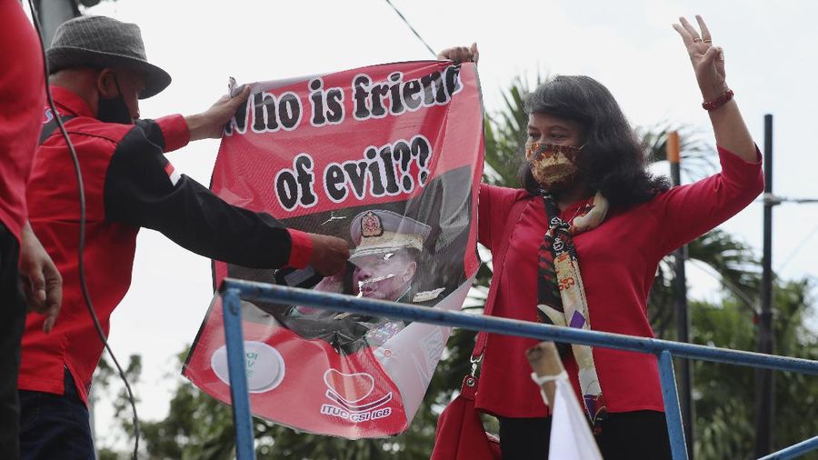 Labor activists destroy a poster of a defaced image of Commander in Chief, Sen. Gen. Min Aung Hlaing during a protest outside the Embassy of Myanmar in Jakarta, Indonesia , Wednesday, March 10, 2021. Dozens of Indonesian labor activists angered over the military coup in Myanmar protested Wednesday outside the Myanmar Embassy in the Indonesian capital. (AP Photo/Achmad Ibrahim)